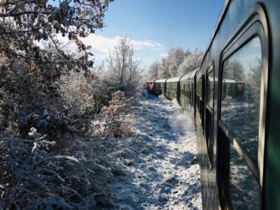 Wo fährt der Orient Express? Auf den Spuren des Luxuszuges Heute steht der berühmte Name für mehrere Luxuszüge mit unterschiedlichen Routen. Besonders bekannt ist der Venice Simplon Orient Express, der unter anderem Paris, Venedig, Wien, Budapest und Istanbul miteinander verbindet. Seine historischen Spuren führen zurück zur legendären Strecke von Paris nach Istanbul. Aktuelle Routen, Reisedauer und Preise zeigen, wie viel vom ursprünglichen Mythos bis heute erhalten geblieben ist. Wo fährt der Orient Express heute? Einen einzigen Orient Express mit fester Route gibt es heute nicht mehr. Der historische Linienzug wurde eingestellt. Unter dem berühmten Namen verkehren inzwischen mehrere Luxuszüge. Am bekanntesten ist der Venice Simplon-Orient-Express von Belmond. Seine klassische Strecke führt von Paris nach Venedig. Weitere Reisen verbinden Paris unter anderem mit Wien, Budapest, Prag und Amsterdam. Ausgewählte Fahrten führen weiterhin von Paris nach Istanbul und orientieren sich teilweise an der historischen Route. Zusätzlich fährt der La Dolce Vita Orient Express auf verschiedenen Strecken durch Italien. Wo der Orient Express heute fährt hängt deshalb vom gewählten Zug und Reisetermin ab. Die historische Route von Paris nach Istanbul Am 4. Oktober 1883 begann die erste vollständige Reise des damaligen Express d’Orient am Pariser Gare de l’Est. Der Zug führte über Straßburg, München, Wien, Budapest und Bukarest bis ins rumänische Giurgiu. Anders als häufig angenommen erreichten die Reisenden Istanbul noch nicht durchgehend auf Schienen. Von Giurgiu ging es per Fähre über die Donau nach Ruse und anschließend mit einem weiteren Zug nach Varna. Das letzte Stück bis ins damalige Konstantinopel legten die Passagiere mit einem Dampfschiff zurück. Erst später wurde die gesamte Strecke ohne Schiffsverbindung befahrbar. Nun verlief die historische Route von Paris nach Istanbul über Straßburg, München, Wien, Budapest, Belgrad und Sofia. Ab 1919 ergänzte der Simplon-Orient-Express das Streckennetz mit einer südlicheren Verbindung über Lausanne, Mailand, Venedig, Triest und Zagreb. Dadurch gab es im Laufe der Jahrzehnte mehrere Routen unter dem berühmten Namen. Der Venice Simplon-Orient-Express und seine Routen 2026 Der Venice Simplon-Orient-Express von Belmond verkehrt 2026 auf mehreren Strecken durch Europa. Als klassische Route gilt weiterhin die Verbindung von Paris nach Venedig. Daneben stehen kürzere Städtereisen sowie mehrtägige Fahrten bis nach Istanbul im Fahrplan. Zu den wichtigsten Routen des Venice Simplon-Orient-Express gehören: Paris nach Venedig: Die bekannteste Route führt über Nacht durch Frankreich, die Schweiz und Norditalien. Paris nach Wien, Prag oder Budapest: Ausgewählte Reisen verbinden die französische Hauptstadt mit bedeutenden Metropolen Mitteleuropas. Teilweise werden auch Hin- und Rückfahrten ab Paris angeboten. Paris nach Istanbul: Auf der fünftägigen Reise verbringen Gäste drei Nächte im Zug sowie jeweils eine Nacht in Budapest und Bukarest. Angeboten wird die Strecke auch in umgekehrter Richtung. Paris nach Rom: Eine weitere Verbindung führt über die Alpen bis in die italienische Hauptstadt. Amsterdam oder Brüssel nach Venedig: Einzelne Fahrten starten in den Niederlanden oder Belgien und führen über mehrere europäische Länder nach Italien. Paris nach Florenz, Portofino oder an die Amalfiküste: Mit der Reihe Villeggiatura by Train ergänzt Belmond 2026 das Angebot um besondere Italienreisen. Neu ist die Route nach Pompeji mit anschließendem Aufenthalt an der Amalfiküste. Nicht jede Strecke wird regelmäßig bedient. Viele längere Reisen finden nur an ausgewählten Terminen statt. Abfahrtsorte, Zwischenstopps und Fahrzeiten können sich je nach Verbindung unterscheiden. Dadurch bleibt der Zug weniger ein klassisches Verkehrsmittel als eine nostalgische Bahnreise durch Europa. Von Paris nach Venedig: Die bekannteste heutige Strecke Zu den bekanntesten Fahrten des Venice Simplon-Orient-Express gehört die Reise von Paris nach Venedig. Nach der Abfahrt am Nachmittag führt die Route über Frankreich und durch die Alpen nach Norditalien. Rund 24 Stunden später erreicht der Zug den Bahnhof Venezia Santa Lucia direkt an der Lagune. Während der Übernachtung im historischen Schlafwagen erleben die Reisenden den besonderen Charakter des Luxuszuges. Restaurierte Waggons im Stil der 1920er Jahre, elegante Speisewagen und eine Bar mit Livemusik prägen die Fahrt. Damit verbindet die Strecke zwei europäische Metropolen mit jener nostalgischen Eleganz, für die der Orient Express bis heute bekannt ist. Paris nach Istanbul: Die legendäre Reise quer durch Europa Als bekannteste heutige Route des Venice Simplon-Orient-Express gilt die Fahrt von Paris nach Venedig. Nach der Abreise am Nachmittag führt die Strecke über Frankreich und die Schweiz bis nach Norditalien. Etwa 24 Stunden später erreicht der Luxuszug den Bahnhof Venezia Santa Lucia direkt an der Lagune. Eine Nacht verbringen die Reisenden in historischen Schlafwagen mit liebevoll restaurierten Abteilen. Elegante Speisewagen, mehrgängige Menüs und die berühmte Bar mit Livemusik prägen das Erlebnis an Bord. So verbindet die Strecke zwei europäische Metropolen mit dem nostalgischen Ambiente der 1920er Jahre, für das der Orient Express bis heute bekannt ist. Reisedauer, Preise und Komfort an Bord Auf der Strecke von Paris nach Venedig wird deutlich, dass beim Venice Simplon-Orient-Express nicht allein das Ziel zählt. Reisedauer und Preis richten sich nach Route, Termin und gewähltem Abteil während der Komfort von nostalgisch bis außergewöhnlich luxuriös reicht. Wie lange dauert eine Reise im Orient Express? Zwischen Paris und Venedig dauert die Fahrt rund 24 Stunden. Reisende verbringen dabei eine Nacht im Zug. Auch Verbindungen nach Wien, Budapest oder Prag erstrecken sich meist über zwei Tage mit einer Übernachtung an Bord. Deutlich länger dauert die Reise von Paris nach Istanbul. Sie umfasst sechs Tage und fünf Nächte. Drei Nächte verbringen die Gäste im Zug. Hotelübernachtungen in Budapest und Bukarest sowie Besichtigungen entlang der Route ergänzen das Programm. Preise und Komfort im Venice Simplon-Orient-Express Für die Strecke von Paris nach Venedig beginnen die Preise bei etwa 4.275 britischen Pfund pro Person in einer historischen Kabine bei Doppelbelegung. Fahrten nach Istanbul kosten mindestens einen hohen fünfstelligen Betrag. Belmond weist sämtliche Preise als Richtwerte aus, die sich nach Termin und Verfügbarkeit verändern können. Zum Fahrpreis gehören das gebuchte Abteil, mehrgängige Mahlzeiten und ausgewählte Getränke in den Restaurantwagen. Historische Kabinen besitzen ein Waschbecken während sich die Toilette am Ende des Waggons befindet. Suiten verfügen über ein eigenes Marmorbad. Grand Suiten bieten zusätzlich einen Wohnbereich, Champagner und Kaviar sowie einen rund um die Uhr erreichbaren Steward. Fazit: Wo fährt der Orient Express? Auf den Spuren des Luxuszuges Einen einzigen Orient Express mit fester Strecke gibt es heute nicht mehr. Der Venice Simplon-Orient-Express fährt 2026 vor allem zwischen Paris und Venedig. Ausgewählte Routen führen außerdem nach Wien, Budapest, Prag, Amsterdam und Istanbul. Historisch begann der Mythos mit der Verbindung von Paris nach Istanbul. Restaurierte Waggons, elegante Speisewagen und luxuriöse Abteile lassen den Charakter des berühmten Zuges bis heute weiterleben. Welche Route gefahren wird hängt vom gewählten Angebot und Reisetermin ab. FAQs: "Wo fährt der Orient Express?" Welche Kleidung trägt man im Orient Express? An Bord des Venice Simplon Orient Express gilt eine elegante Kleiderordnung. Tageszeit Empfohlene Kleidung Tagsüber Gepflegte Tageskleidung Abendessen Formelle Abendgarderobe Herren am Abend Anzug oder Smoking Damen am Abend Cocktailkleid oder Abendkleid Jeans, kurze Hosen und Sportschuhe sind nicht erwünscht. Besonders zum Dinner kleiden sich viele Gäste festlich. Eine Pflicht zum Smoking besteht jedoch nicht. Dürfen Kinder im Venice Simplon Orient Express mitreisen? Kinder sind im Venice Simplon Orient Express grundsätzlich willkommen. Kleinkinder unter zwei Jahren reisen laut Belmond kostenlos. Eltern müssen passende Babynahrung und ein eigenes Reisebett mitbringen. Für ältere Kinder gelten abhängig von Route und Unterbringung unterschiedliche Preise. Wegen des formellen Ambientes, der langen Mahlzeiten und des begrenzten Platzes eignet sich die Zugreise vor allem für Kinder, die sich mit einer ruhigen Reisegestaltung wohlfühlen. Wie viel Gepäck darf man in den Orient Express mitnehmen? Der begrenzte Stauraum in den historischen Waggons macht eine kompakte Reiseausstattung erforderlich. Pro Person sind normalerweise ein Handgepäckstück, eine Kleiderhülle oder Reisetasche und ein Koffer bis 23 Kilogramm vorgesehen. Der große Koffer wird separat gelagert und steht während der Fahrt nicht zur Verfügung. Kleidung, Medikamente und persönliche Gegenstände für die Übernachtung gehören deshalb ins Kabinengepäck. Kleiderhüllen eignen sich besonders für die Abendgarderobe. Gibt es WLAN und Handyempfang an Bord? wo fährt der orient express